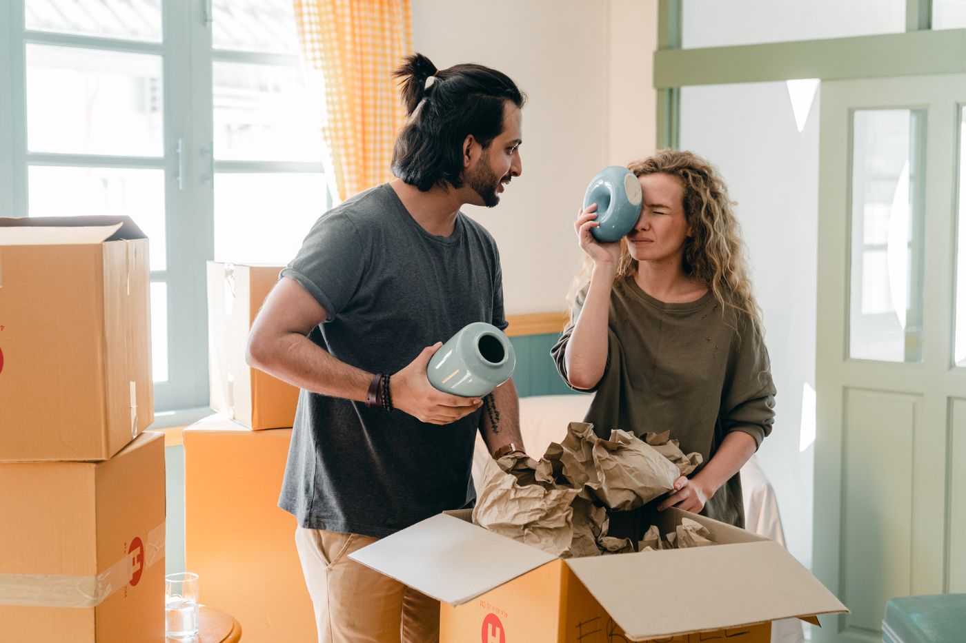 Couple packing household items into cardboard boxes