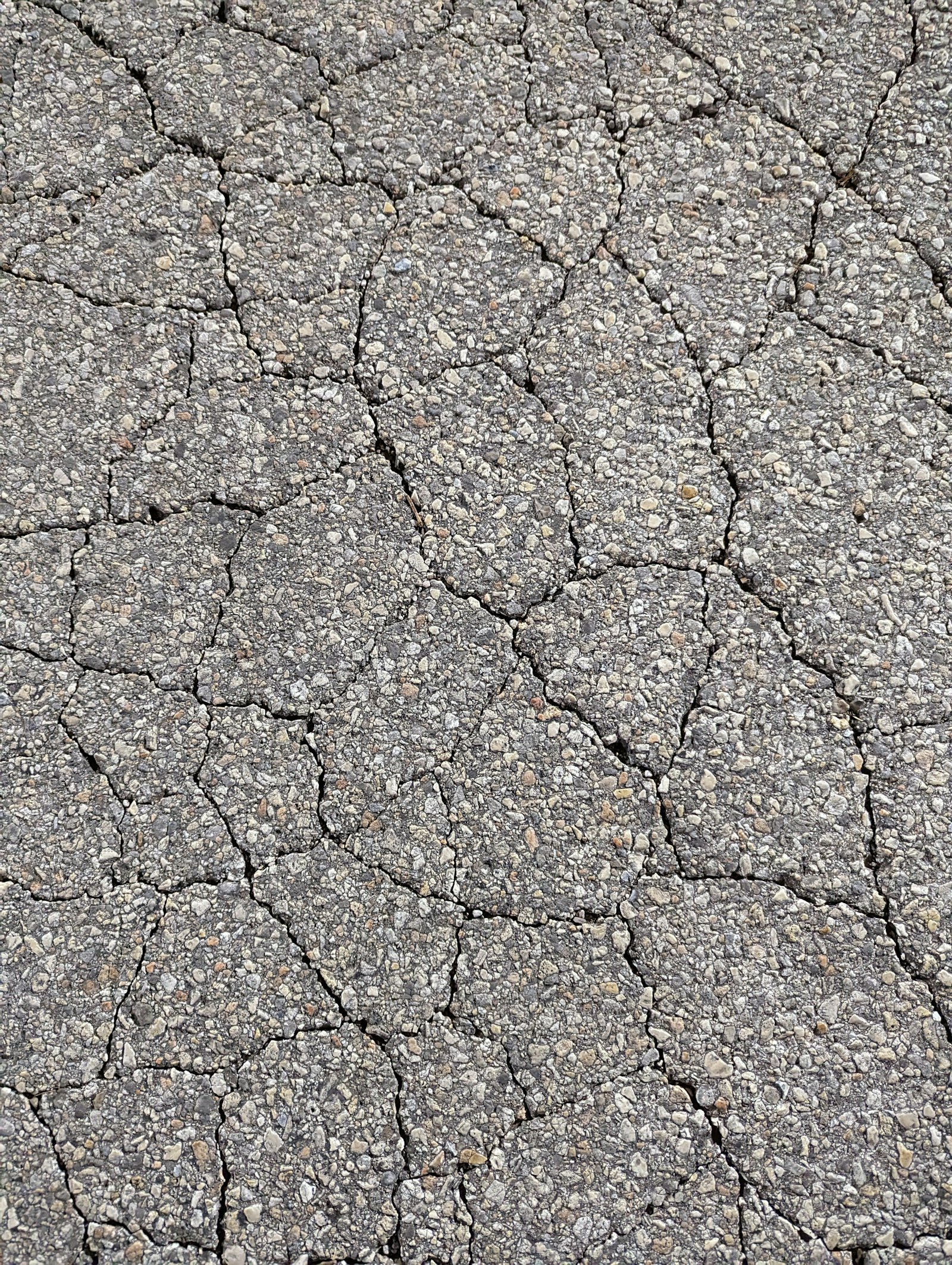 Close-up of cracked, weathered asphalt pavement ready for light milling or surface preparation