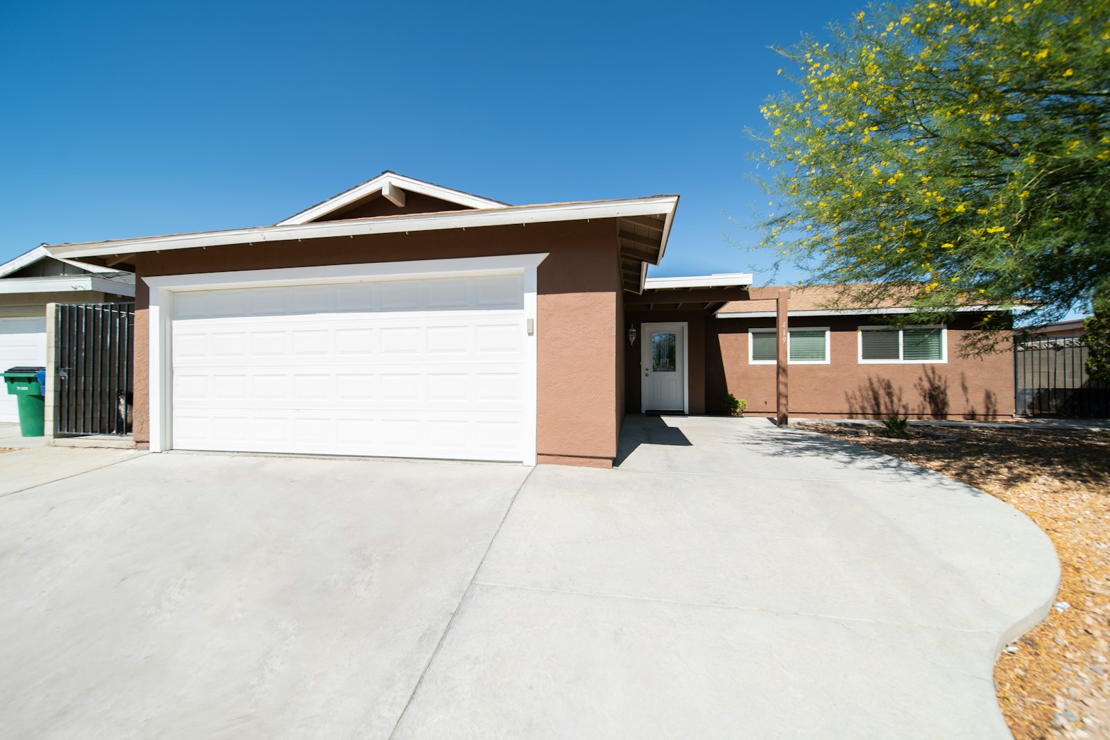 Suburban home with a concrete driveway and gravel landscaping in the front yard